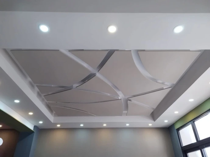 Cielo falso residencial con diseños geométricos y curvos e iluminación empotrada.