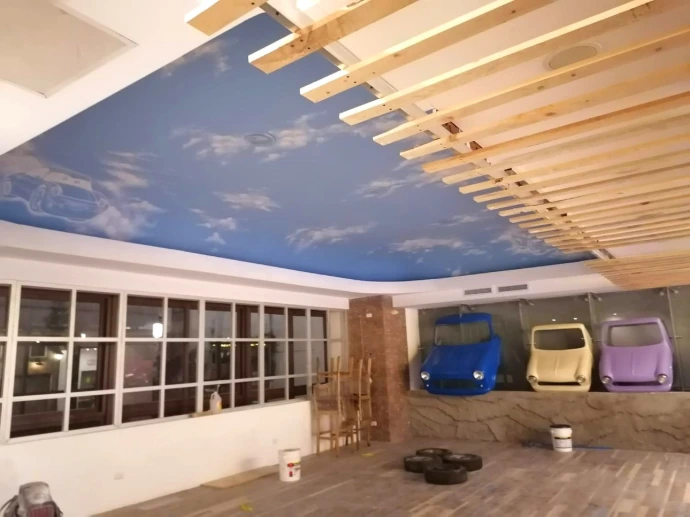 Cielo falso con diseño de cielo azul y listones de madera durante la ejecución de Pizza Grizzly, Cayalá.